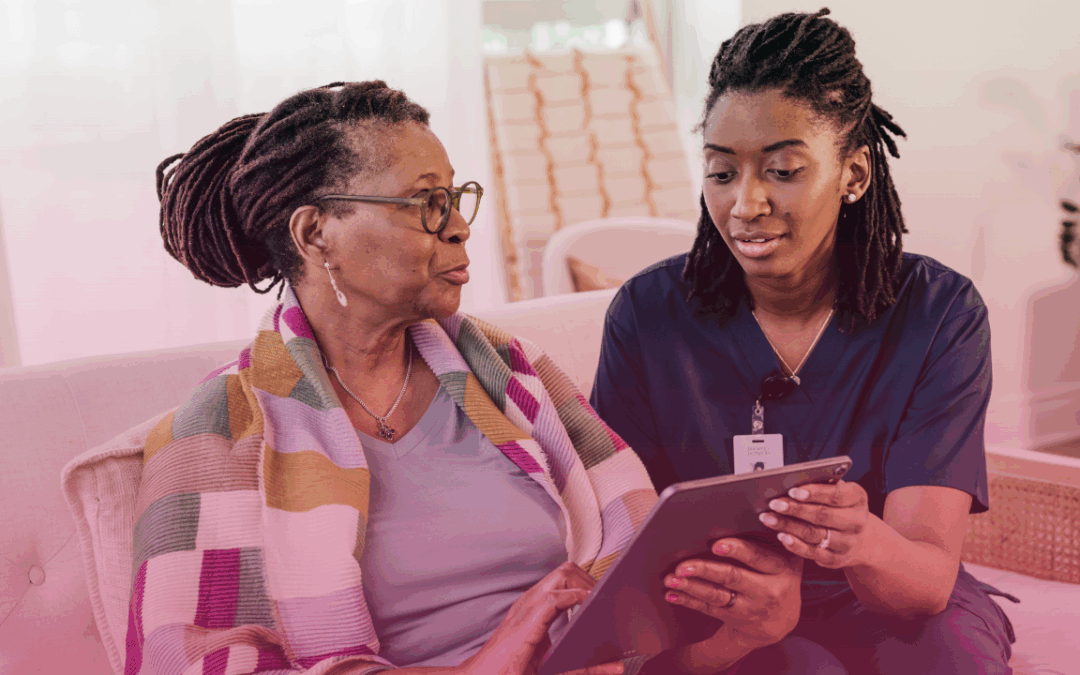 a senior woman comfortably sitting at with her caregiver enjoying home care